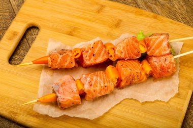 Pişmeye hazır baharatlı çiğ somon şişi.