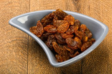 Ahşap arka plan üzerinde kase kuru kuru üzüm