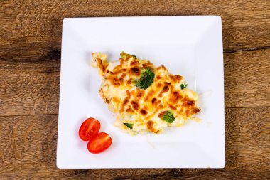 Ahşap masa üzerinde peynirli fırında lahana