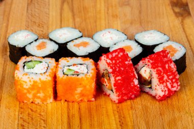 Suşi rulo seti ahşap arka plan üzerinde. Japon yemekleri