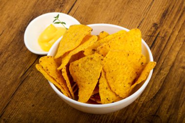 Ahşap masa üzerinde peynir soslu cips