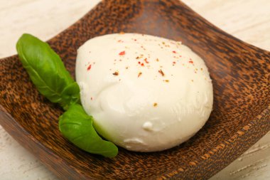 Fesleğenli mozzarella peyniri ahşap plaka üzerinde bırakır