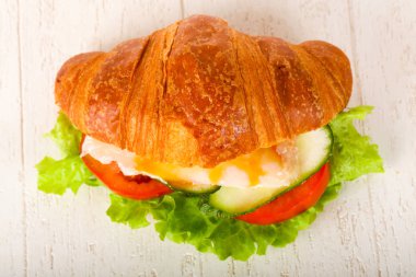 Kruvasan tavuk ve ahşap masa üzerinde domates ile