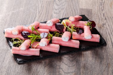 Jambon peynir rulo plaka üzerinde ahşap masaya doldurulmuş.