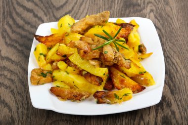 Ahşap masa üzerinde biberiye ile servis domuz eti ile kızarmış patates