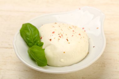 Fesleğenli mozzarella peyniri tahta masada bırakır