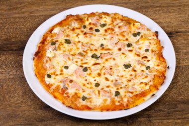 Somon ve yumuşak peynir ile Kapari ahşap masa üzerinde pizza