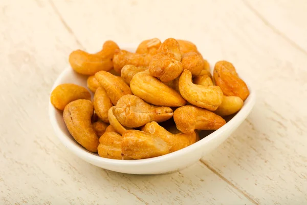 Cashewnoten Heap Witte Plaat Houten Achtergrond — Stockfoto