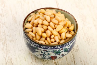 Sedir fındık yığın içinde kase ahşap arka plan üzerinde