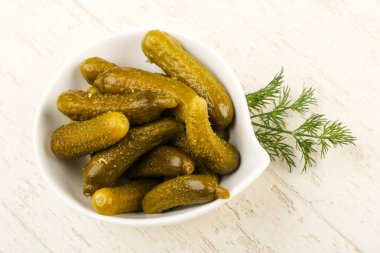 Ahşap arka plan üzerinde kaseye Picled salatalık