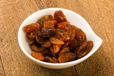 Ahşap arka plan üzerinde kase kuru kuru üzüm