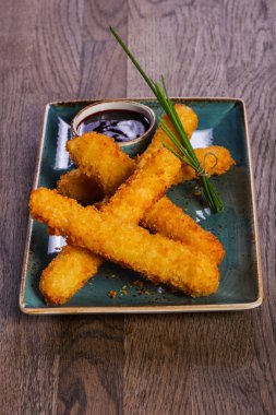 Peynir soslu yeşil soğan ahşap masaya servis yapışıyor