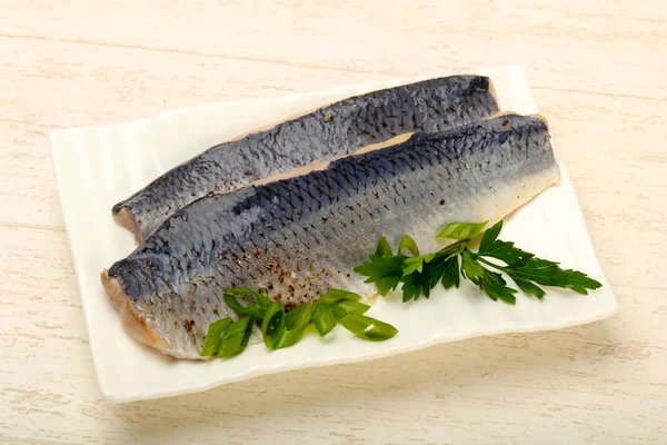 Beyaz plaka üzerinde bitkilerle cilt ile ringa balığı filetosu