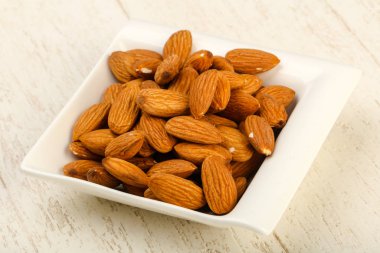 Badem ahşap arka plan üzerinde kase