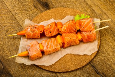 Pişmeye hazır baharatlı çiğ somon şişi.