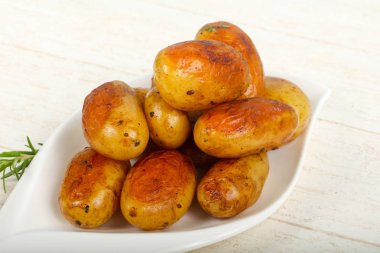 Fırında patates ahşap masa üzerinde rosemary ile genç