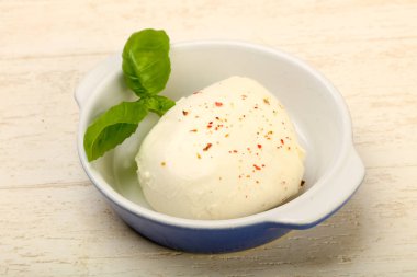 Fesleğenli mozzarella peyniri tahta masada bırakır
