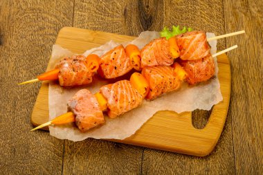 Pişmeye hazır baharatlı çiğ somon şişi.