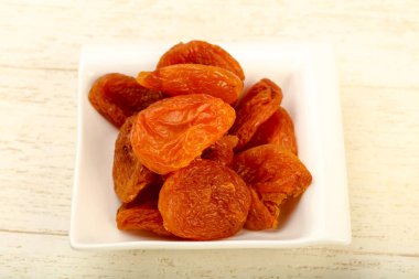 Kuru Kayısı yığın içinde kase ahşap arka plan üzerinde