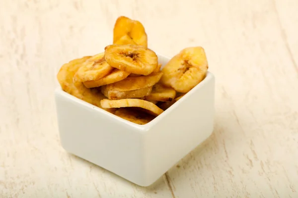 Dry banana chips on background