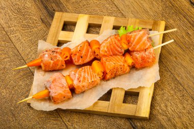 Pişmeye hazır baharatlı çiğ somon şişi.