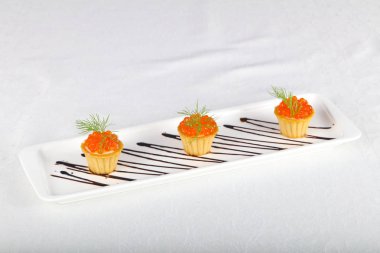 Beyaz masada kırmızı havyar tartalets