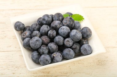 Kase ahşap arka plan üzerinde yabanmersini