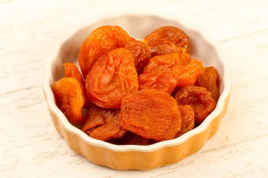 Kuru Kayısı yığın içinde kase ahşap arka plan üzerinde