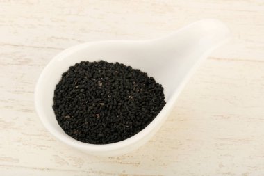 Ahşap arka plan üzerinde siyah çörek otu tohumu yığın