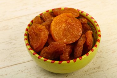 Kuru Kayısı yığın içinde kase ahşap arka plan üzerinde