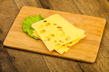 Ahşap arka plan üzerinde dilimlenmiş peynir salata yaprakları