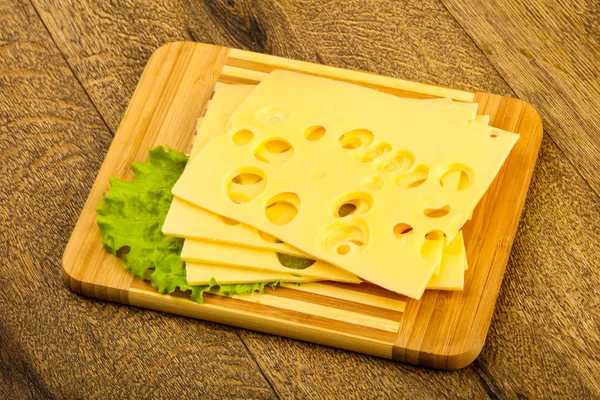 Ahşap arka plan üzerinde dilimlenmiş peynir salata yaprakları