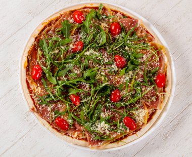 Hamon ve roka ile pizza.