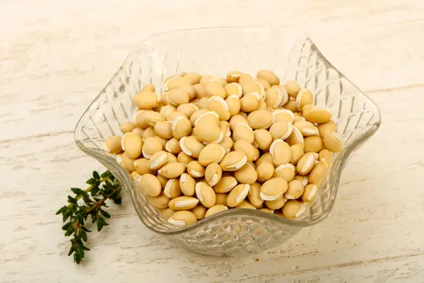 Kase ahşap arka plan üzerinde çiğ beyaz fasulye