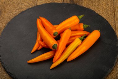 Sıcak sarı biber yığın ahşap arka plan üzerinde