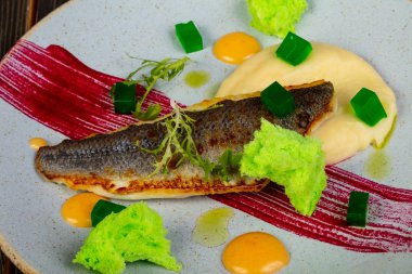 Kızarmış levrek balık fileto salata yaprakları ile