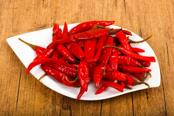 Ahşap arka plan üzerinde kırmızı biber biber turşusu