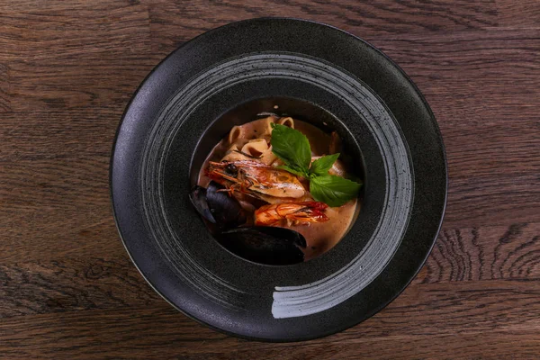 Fesleğen yaprakları ile deniz ürünleri makarna