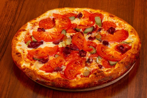 Pizza with sausages and sliced tomato