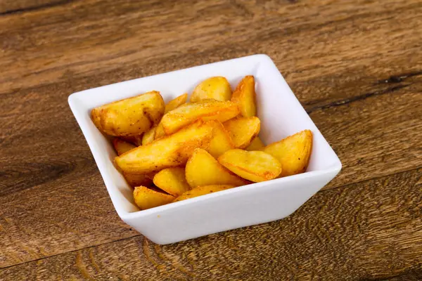 Ahşap arka plan üzerinde rustik lezzetli patates