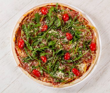 Hamon ve roka ile pizza.