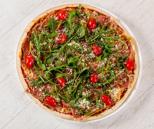 Hamon ve roka ile pizza.