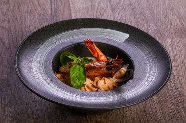 Fesleğen yaprakları ile deniz ürünleri makarna