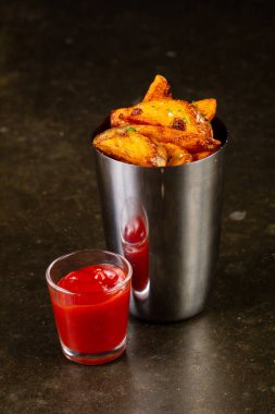 Ahşap arka plan üzerinde soslu kızarmış patates