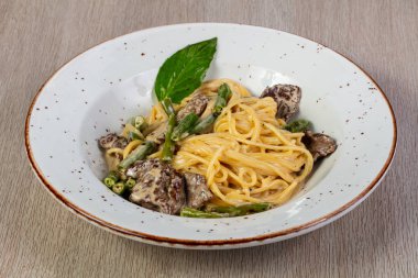 Makarna ile sığır eti ve fesleğen yaprakları