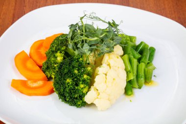 İştah açıcı buğulanmış havuç, brokoli ve pırasa