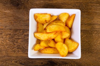 Ahşap arka plan üzerinde rustik lezzetli patates