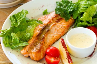 Izgara somon steak sos ve salata yaprakları ile