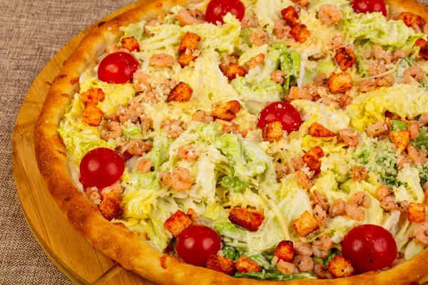 Caesar pizza with prawn and salad leaves