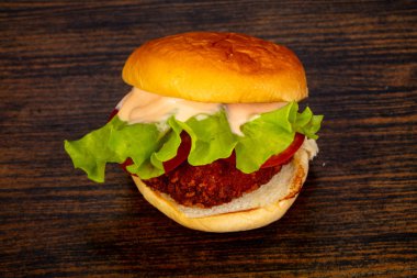 Ahşap arka plan üzerinde lezzetli sıcak burger